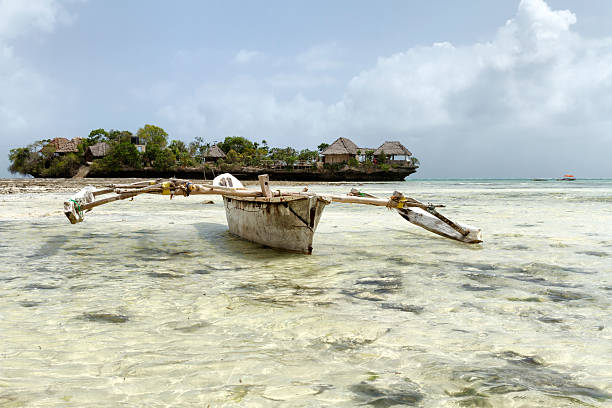 Fishing boat in Zanzibar Fishing boat in Zanzibar with little island on background catamaran sailing stock pictures, royalty-free photos & images