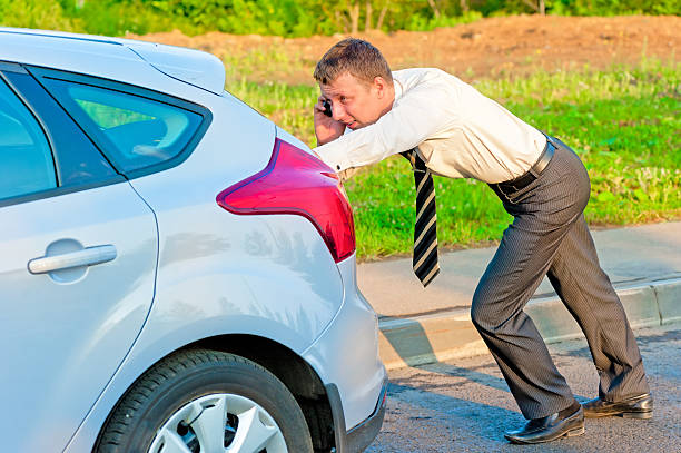 istock Businessman pushing a car and talking on the phone 462918155