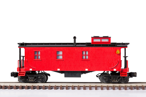 A red model railroad caboose on track.