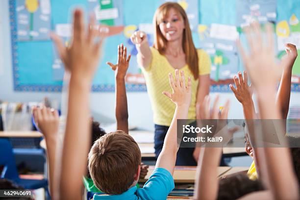 Elementary School Class Raising Hands Stock Photo - Download Image Now - Teacher, Classroom, In Front Of