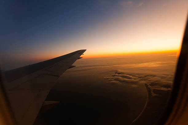 vista dall'aereo al tramonto - wing airplane window sunset foto e immagini stock