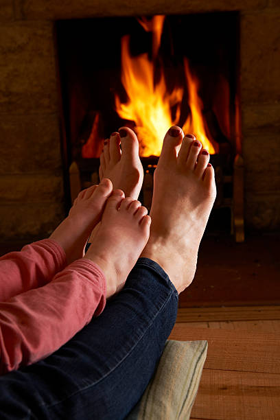 istock Mother And Child Warming Feet By Fire 462944679
