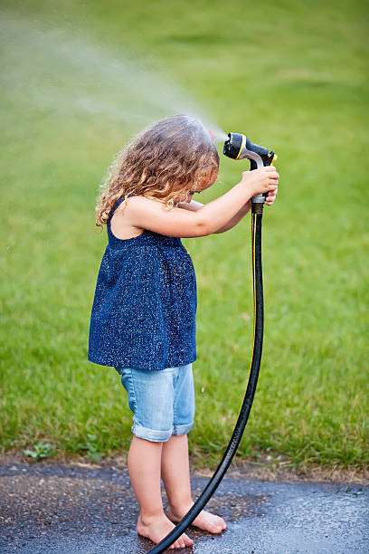 istock Girl With Garden Hose 462950093
