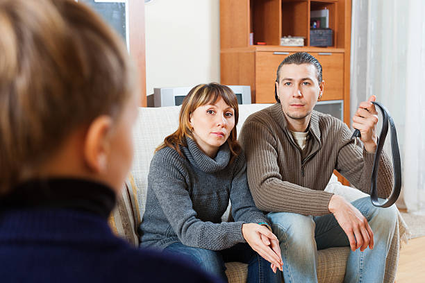 istock Couple with belt berating  son 462953453