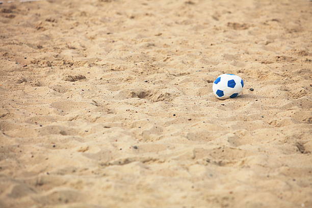 istock soccer ball on sandy beach background 462957591
