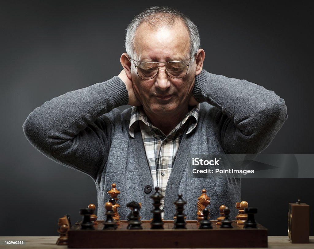 Senior man playing chess Senior man thinking about his next move in a game of chess. Front view. 60-64 Years Stock Photo