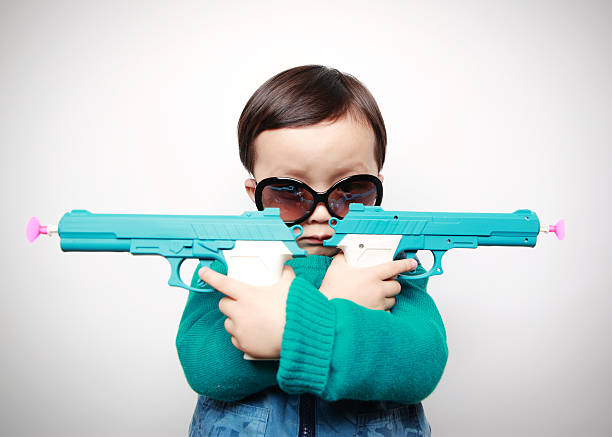 Children playing with toy guns Cute asia children baby gun stock pictures, royalty-free photos & images