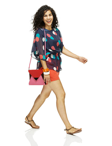 Smiling woman walking with bag on shoulder