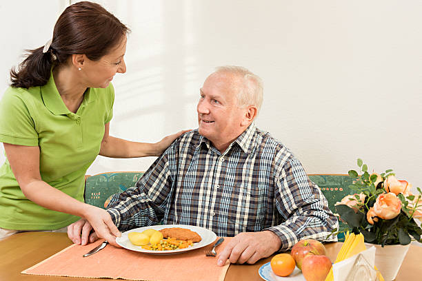 istock Carer giving senior man lunch in the kitchen 462969851