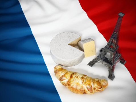 Three symbols of France: Camembert cheese, croissant and Eiffel tower on French flag.