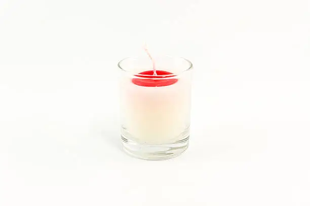 Beautiful colorful candle in glass isolated on white background.