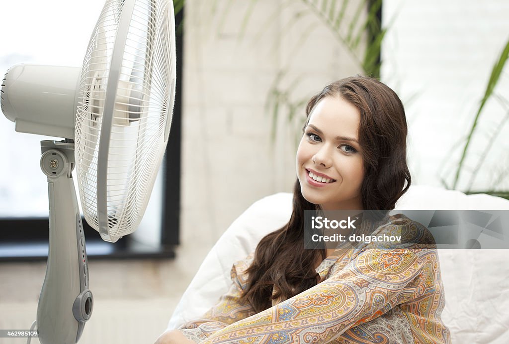 happy and smiling woman sitting near ventilator  happy and smiling woman sitting near ventilator at home Cool Attitude Stock Photo