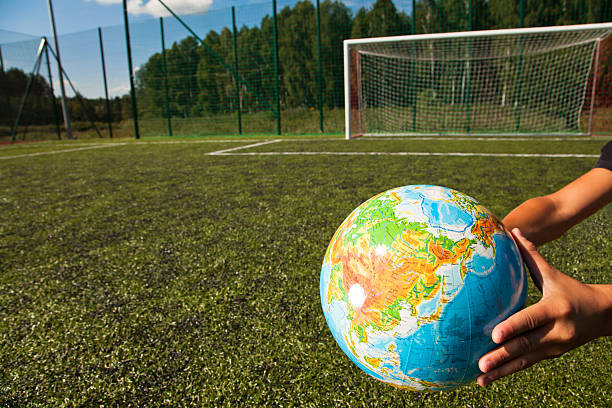 mani tenendo palla mondo - soccer player flash foto e immagini stock