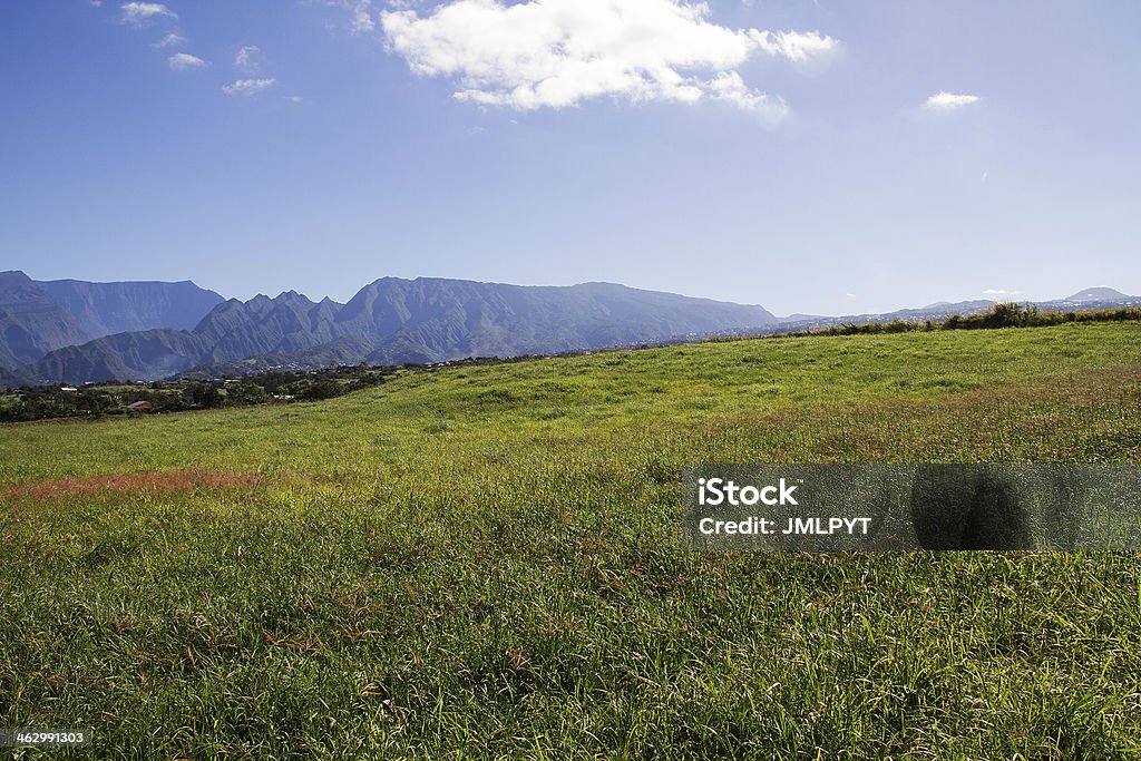 Landscape, mountain, Reunion island, sky blue, cloud Mountainous landscape of the Reunion Island in the Indian Ocean. In the foreground, a field where the sugar cane is going to push(grow), far off the mountain range with an attractive blue sky and white clouds. Awe Stock Photo