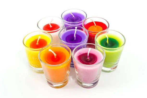 Beautiful colorful candle in glass isolated on white background.