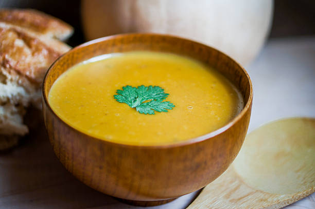 istock Butternut squash soup with homemade bread on wooden background 462998681