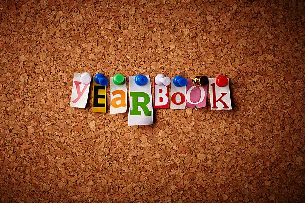 Yearbook - Cut out letters pinned on a cork notice board.