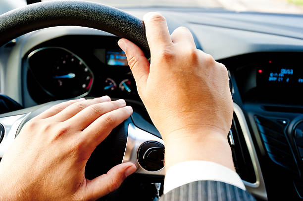 istock male hand holding a car wheel 463005921