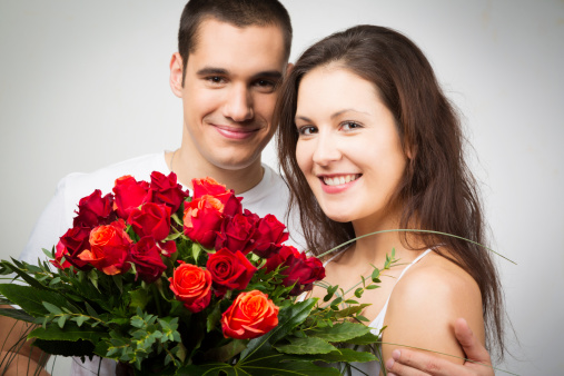 happy valentine's couple holding bouquet of roses