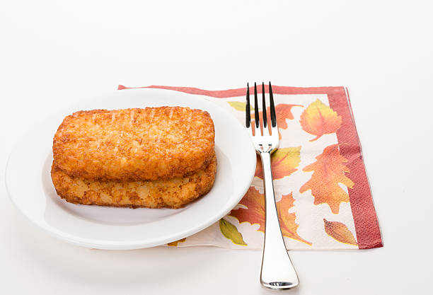 Fresh hash brown Delicious breakfast with fresh hash brown on white dish, decorative napkin, and fork. hash brown stock pictures, royalty-free photos & images