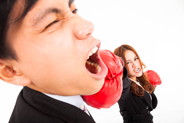 femme d'affaires en tapant sur un homme d'affaires isolé sur fond blanc - women business strength boxing photos et images de collection