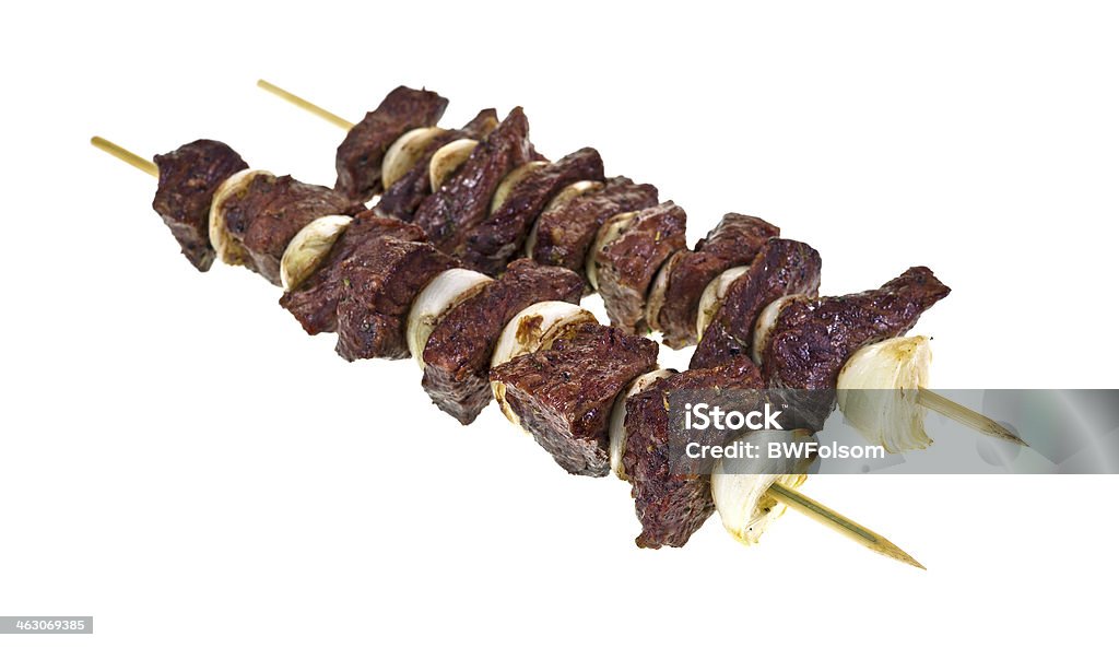 Cooked beef and onion kabobs Two beef and onion kabobs skewered on wood sticks. Beef Stock Photo
