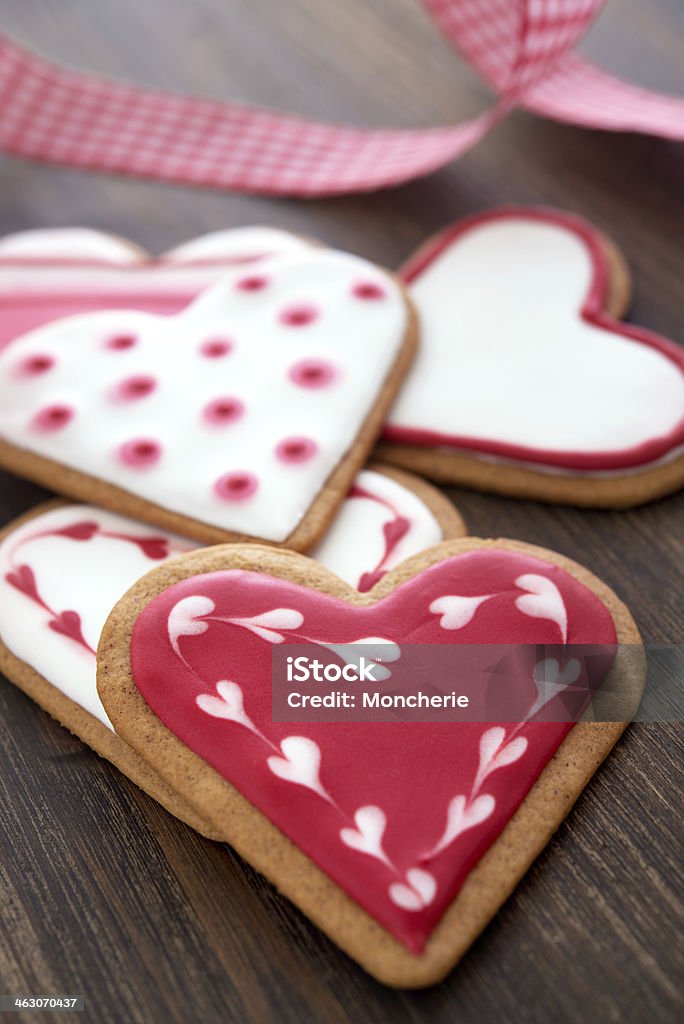 Biscotti a forma di cuore rosso su sfondo in legno - Foto stock royalty-free di Affettuoso
