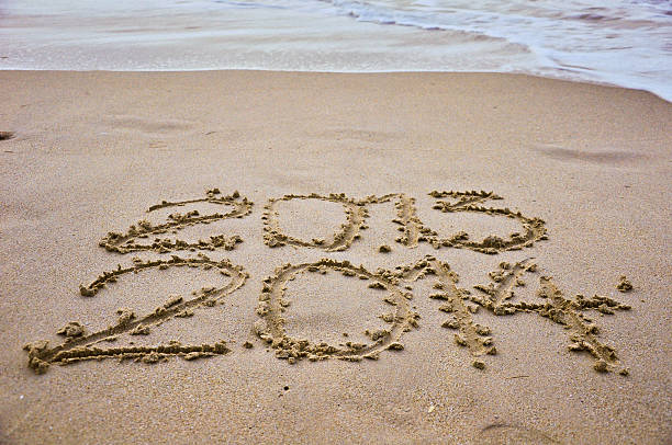 istock close up Year 2014 and 2013 written in the sand 463071419