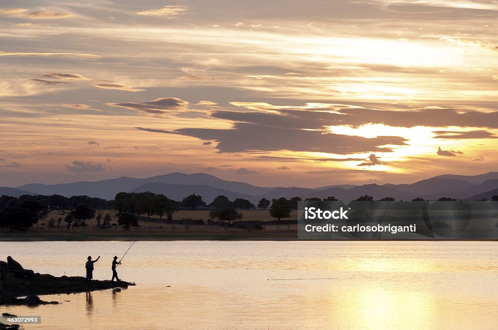 Due uomini Pesca nel lago al tramonto - 3 - Foto stock royalty-free di Acqua