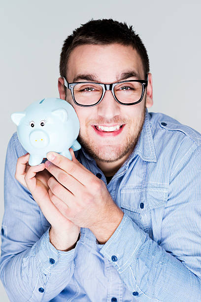 istock Nerd man holding piggy bank 463073365