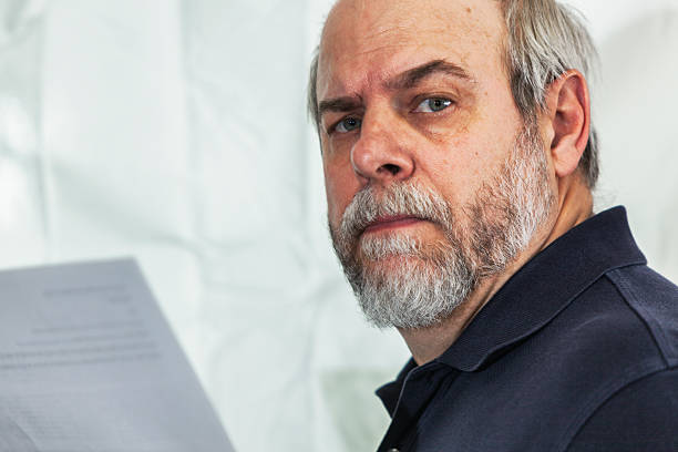 istock Skeptical Senior Businessman Holding Business Document 463080711