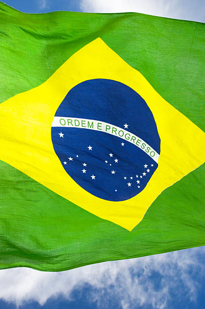 istock Brazilian Flag Waving in Bright Blue Sky 463085039