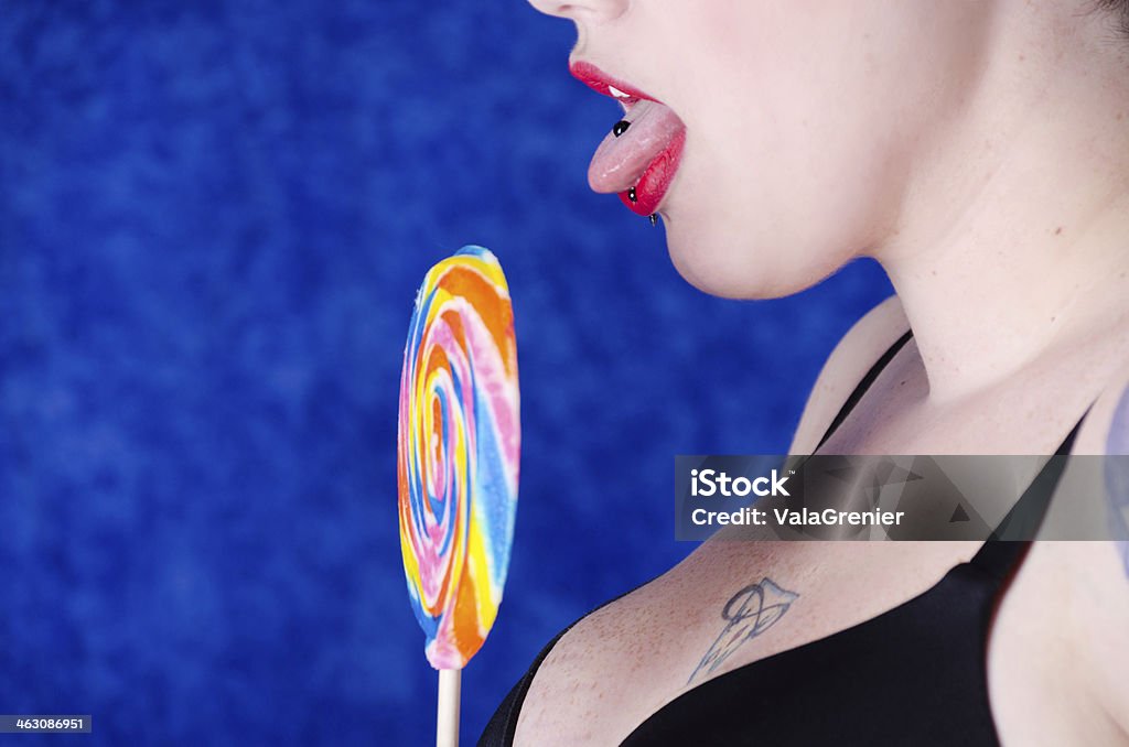 Donna con linguetta traforata in profilo con Lecca-lecca. - Foto stock royalty-free di 30-34 anni