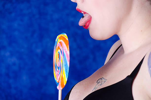 Woman With Pierced Tongue In Profile Holding Lollipop Stock Photo -  Download Image Now - iStock