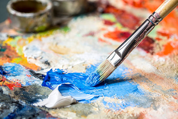 istock Paintbrush with blue oil paint on a classical palette 463088251