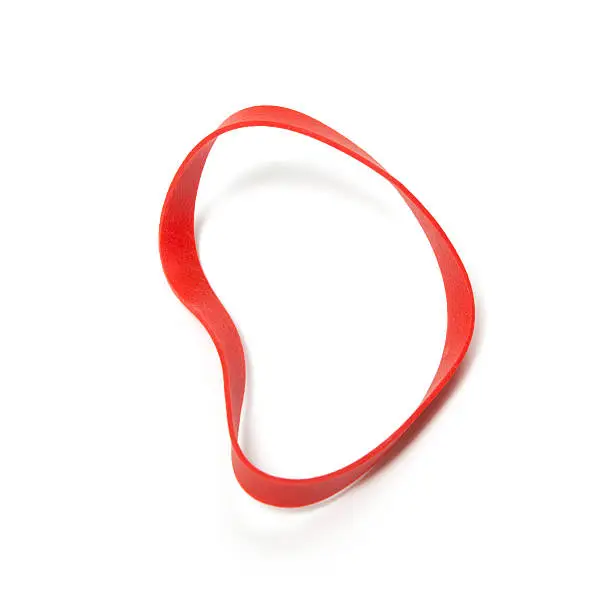 Red rubber band. Studio isolated on a white background with a light shadow.