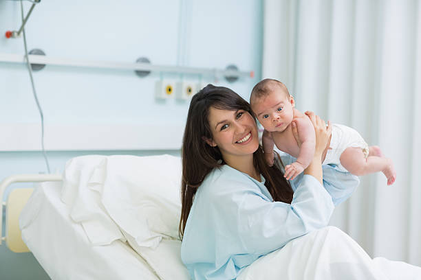 istock Happy mother holding a baby boy in diaper while smiling 463102137
