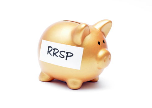 Close up of a mass produced piggy bank with RRSP written on it on a white background, symbolizing a Registered Retirement Savings Plan contribution in Canada. 