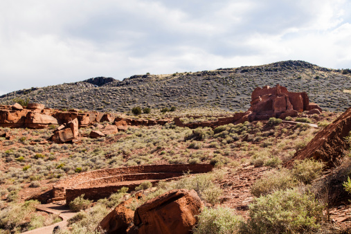 Aguirre Springs in monsoon season, with waters high and vegetation green, a view looking up toward sugarloaf, revealing rocky crags and and forest, with water cascading through the middle