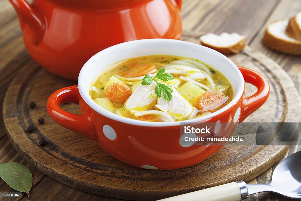 Chicken soup Chicken soup in an orange bowl on the table Animal Stock Photo