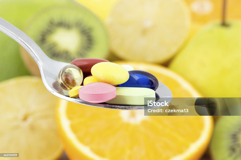 Cuchara repleto de coloridos pastillas - Foto de stock de Complemento vitamínico libre de derechos