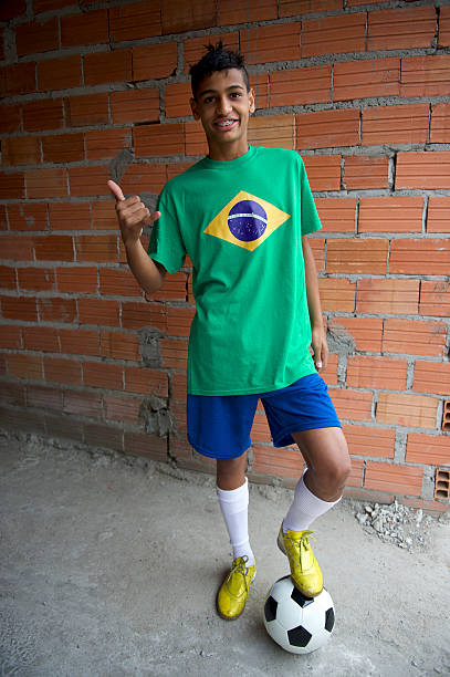 smiling brazilian teen thumbs up with football soccer ball - brasilianische fußballspieler 個照片及圖片檔