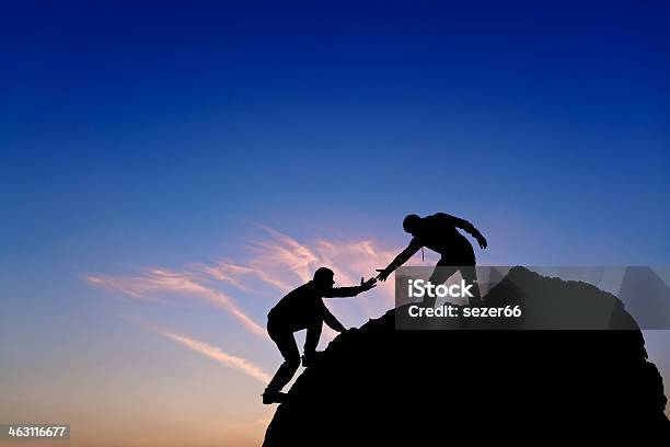 Silhouette Der Helfende Hand Zwischen Zwei Bergsteiger Stockfoto und mehr Bilder von Eine helfende Hand