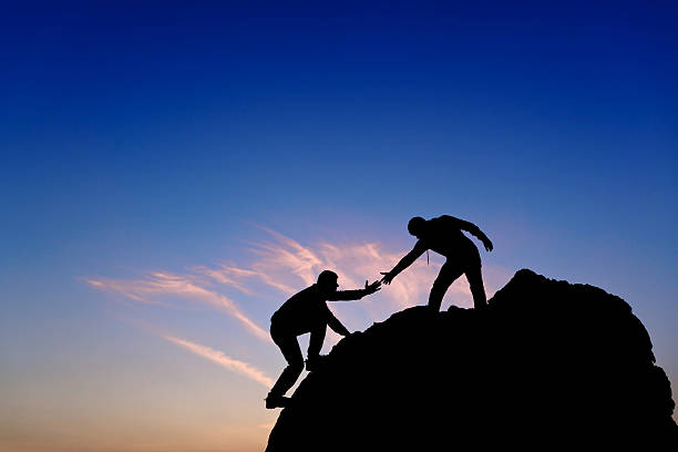 istock Silhouette of helping hand between two climber 463116677