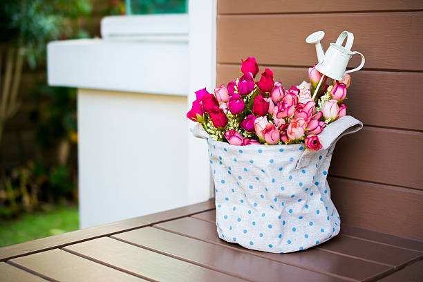 istock Roses with a small watering pot in fabric vase 463140545