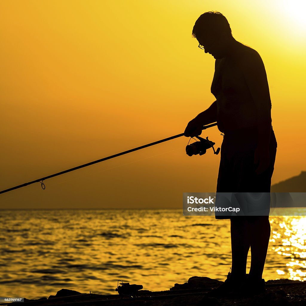 Fisherman's silhouette en la playa - Foto de stock de Acantilado libre de derechos