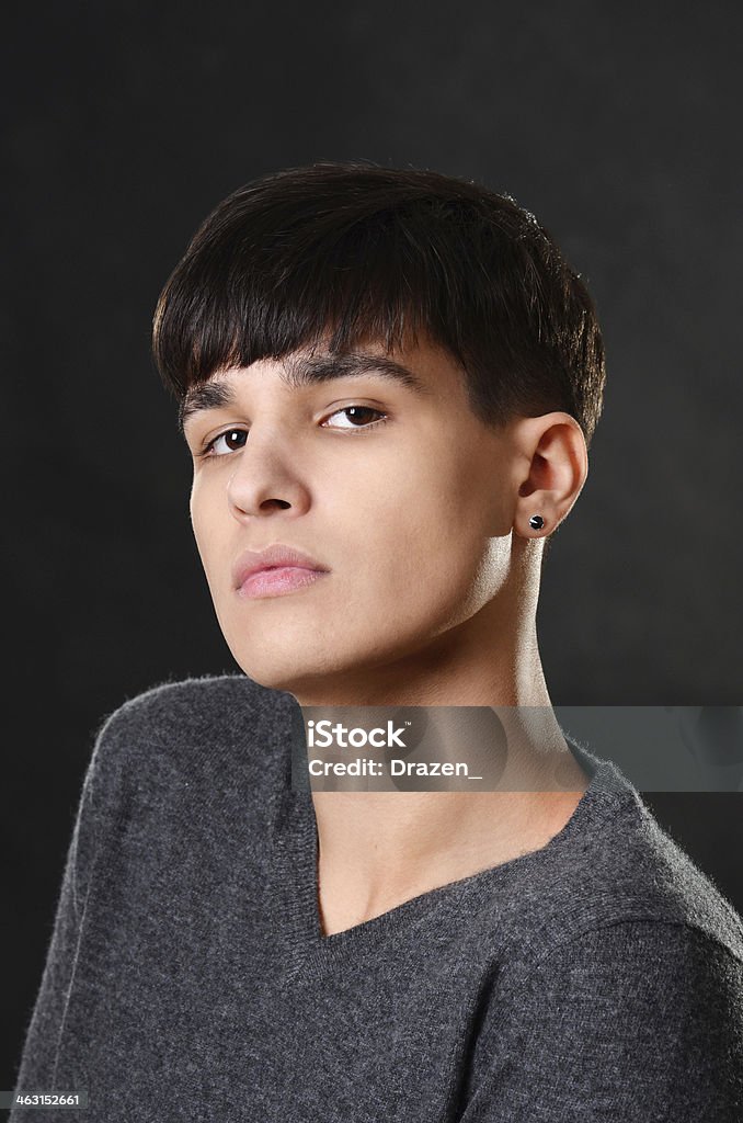 Portrait of handsome dark hair teenager on isolated black background Handsome teenager on isolated background in casual outfit Adolescence Stock Photo