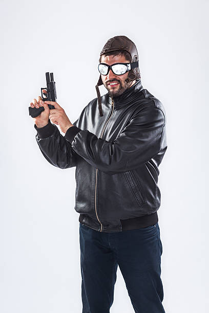 istock Arrogant young man holding a gun pointed upwards 463152871