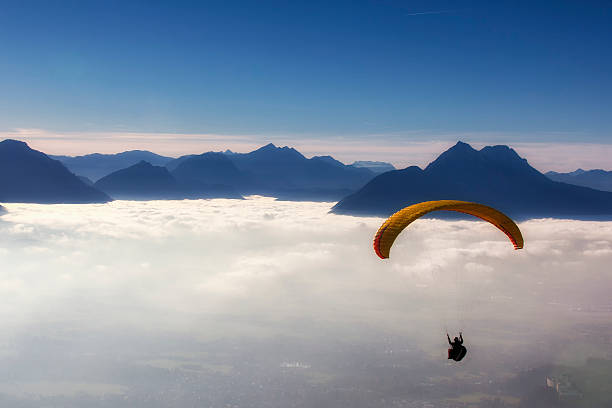 istock View of man skydiving from above the clouds with mountains 463173417