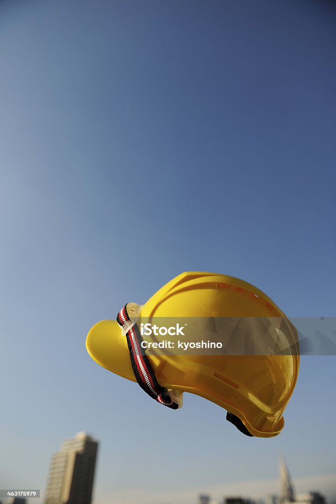 黄色工事用ヘルメットフライング中旬に air アゲインスト澄んだ空 - カラー画像のロイヤリティフリーストックフォト